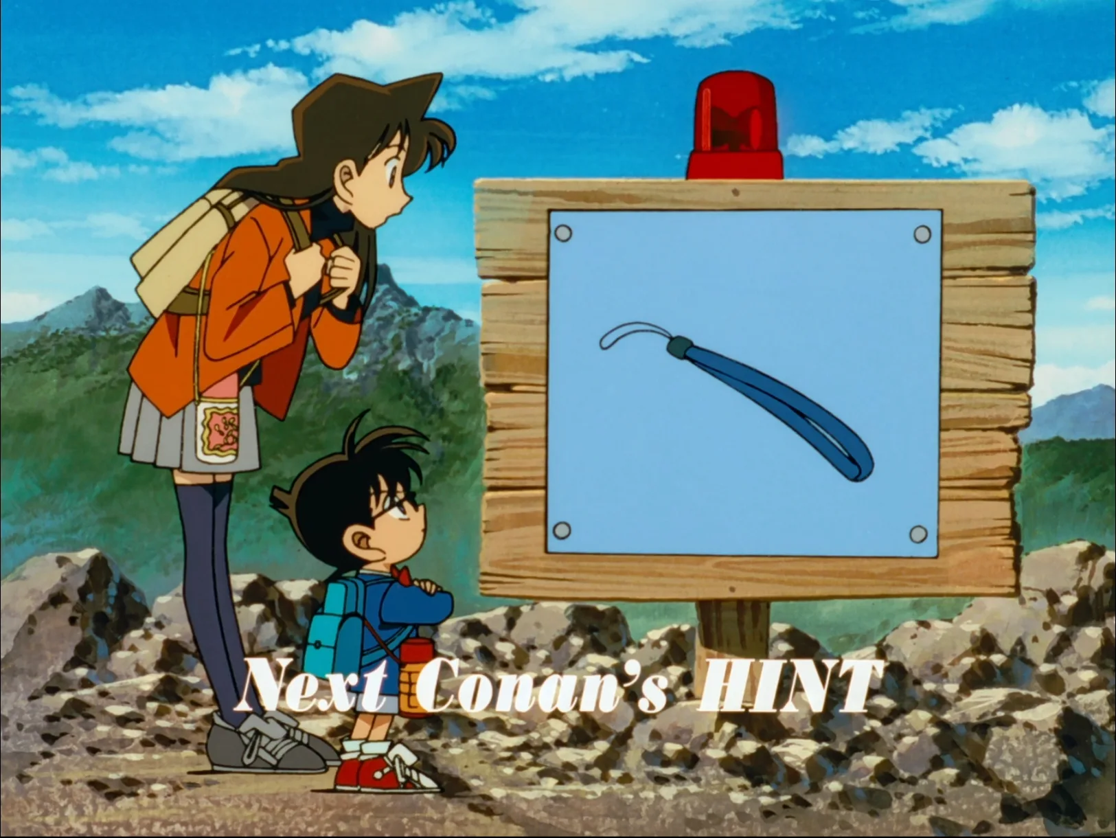 ストラップが描かれたNext Conan's Hintの掲示板を見る蘭とコナン