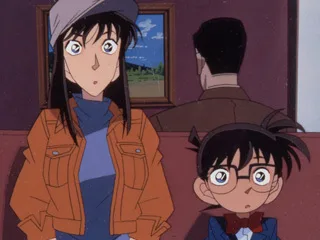 レストランで高山みなみと江戸川コナンが電話中の男を見つめるTVアニメ第81話の公式場面
