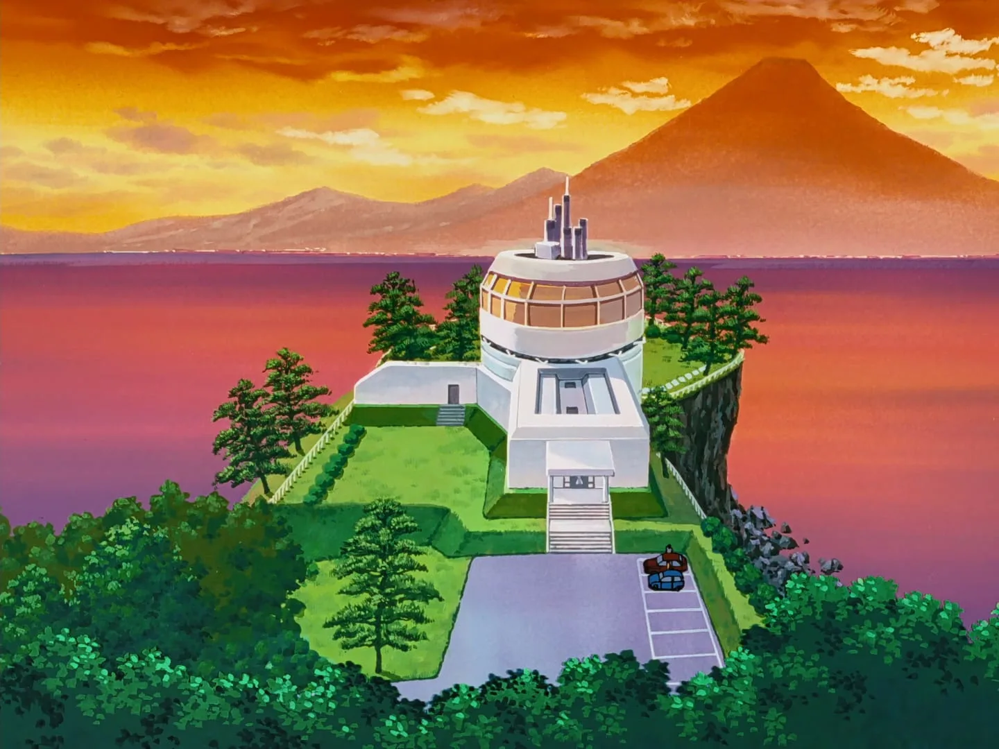 夕焼けの海を望む崖に建つヒマワリ館(回転する円形の2階を持つ金沢邸)