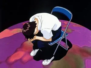 第弐拾伍話終わる世界で折り畳み椅子に座り身体を丸める碇シンジの公式場面画像
